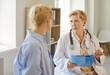 © Studio Romantic - Female doctor leads a consultation with a patient in bright medical clinic, reviewing notes on a clipboard and giving professional advice. Doctor and patient engage in supportive conversation.