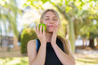 © luismolinero - Young blonde woman at outdoors holding an apple with happy expression