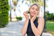 © luismolinero - Young blonde woman at outdoors holding an avocado with happy expression