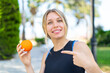 © luismolinero - Young blonde sport woman holding an orange at outdoors and pointing it