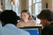 © Maksim Shebeko - Three colleagues share a joyful moment while brainstorming ideas in a bright office setting Generative AI