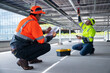 © Washburn - Technicians testing solar panel wiring underneath installation