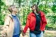 © olezzo - Mother and Daughter Walking Hand in Hand in Summer Park Celebrating Mother’s Day