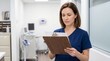 © Janna - Adult woman focused holding medical chart in clinic interior