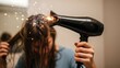 © Vektor Stokart - A surprised woman holds a faulty hairdryer that is actively sparking and emitting smoke near her hair.