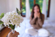 © Farknot Architect - Blurred image of a surprised woman receiving a white flower bouquet at home