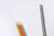 © soya - Colored pencils and blank spiral notebook mockup on white background with copy space