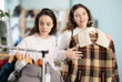 © JackF - Two young women went shopping in a store and together they choose outerwear, they communicate and consult which coats and jackets to buy