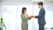 © metamorworks - オフィスでプレゼントを渡すビジネスパーソン