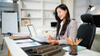 © Stella 16 - Business woman working on tablet paper files for searching and checking unfinished document achieves on folders papers at busy work desk office
