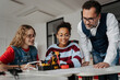 © Halfpoint - High school students working on robotics project with their teacher.