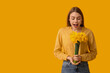 © Pixel-Shot - Surprised young woman with bouquet of daffodil flowers on yellow background