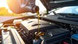 © lumut - A close-up of engine oil being poured into an open car engine