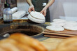 © Studio Peace - Baker placing raw flatbread on a special pillow to cook inside a traditional round tandoor oven.