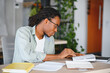 © Serhii - Focused university student studying textbooks at desk