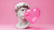 © Olesya - Male bust sculpture blowing large pink heart as a bubblegum bubble. Modern twist on classical art for Valentine day greeting card.