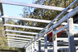 © CoreRock - Unfinished metal roof structure frame against blue sky showing strong silver steel beam construction for industrial building project development