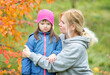 © Ermolaev Alexandr - Mother talks with little girl with Downs syndrome at autumn park