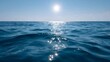© Bussakon - The sun shines brightly over the calm ocean waves casting a shimmering reflection on the water s surface under a clear blue sky