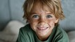 © Pinklife - A close-up of a young boy with freckles smiling brightly, capturing the essence of childhood happiness, innocence, and the joy of being carefree in a simple moment.