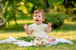 © Tina kids photo - a 9-month-old baby girl is sitting on the grass in the summer and crying
