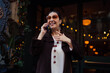 © BullRun - Hispanic woman laughing on phone call with hand to chest, reacting emotionally while communicating, showing genuine human connection in a digitally connected lifestyle.
