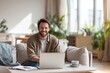 © Popelniushka - Happy man paying bills on a laptop in a cozy living room