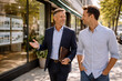 © thodonal - Two men engaging in conversation while walking in the city