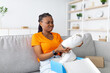 © Prostock-studio - Dissatisfied black female client opening box from online shop and looking at wrong delivered item, unhappy with received sneaker shoes, disliking footwear after unboxing package