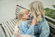 © ADDICTIVE STOCK - Mom and daughter sharing a joyful moment on a bench