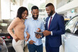 © Prostock-studio - Handsome Car Seller Showing Purchasing Details On Digital Tablet To Young Black Couple In Dealership Center, Happy African American Spouses Buying New Vehicle In Automobile Showroom, Closeup