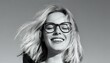 © Iulia - A woman with closed eyes and a wide smile evokes a sense of joy and happiness. She wears large round glasses, which give her a playful and stylish look.