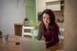 © Migma_Agency - Young woman drinking coffee while working on laptop