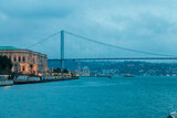 A panoramic view from the water at night of the Bosphorus Bridge and the Ortakoy Mosque in Istanbul, Türkiye.
