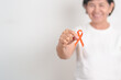 © Jo Panuwat D - Elderly with Orange Ribbon for September Leukemia, March Kidney cancer day, Multiple Sclerosis, Self Injury Awareness month, November Complex Regional Pain Syndrome, CRPS, COPD disease concept