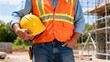 © FreemiumStock - Close-up of person with hard hat and reflective vest, representing construction safety standards and field readiness under sunlight