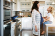 © BuyoutReese06/peopleimages.com - Pregnant, woman and laughing with son, kitchen and bonding with child on break, happy and discussion. Boy, affection and conversation with mom in home, flare and kid with smile for unborn sibling