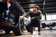 © Drazen - Happy man buying new vehicle at car dealership.