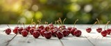 Red sweet cherry spread across a white wooden table