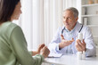 © Anastasiya - Senior male doctor explaining medication and holding pill bottle while consulting female patient, prescription guidance and pharmaceutical care concept