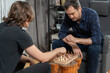 © dimetradim - Focused father looking at adult son making move on chessboard. Two relatives playing strategy game in living room. Family bonding and leisure activity during weekend indoors.