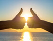 © magele-picture - 2 Hände halten Daumen hoch vor der Sonne