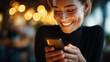© Nataliya - Woman smiling while looking at cell phone, faceless person, mobile technology enjoyment, digital connectivity, casual moment, defocused background, with copy space