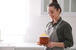 © New Africa - Young woman with traditional decorated Easter cake in kitchen. Space for text