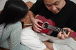 © airdone - Asian father teaching his young daughter how to play the ukulele at home