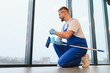 © Serhii - Professional cleaner spraying window glass with squeegee