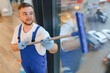 © Serhii - Professional worker cleaning glass window in office