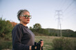 © Cristian Blázquez - Mature woman hiking with poles in nature