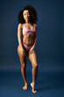 © Bliss - Stylish young African American woman showcasing swimwear in a creative studio setting