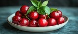 Fresh cherries on a plate with green leaves